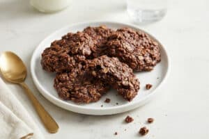 Chunky chocolate oatmeal cookies on a white plate with a gold spoon, No Bake Chocolate Oatmeal Cookies
